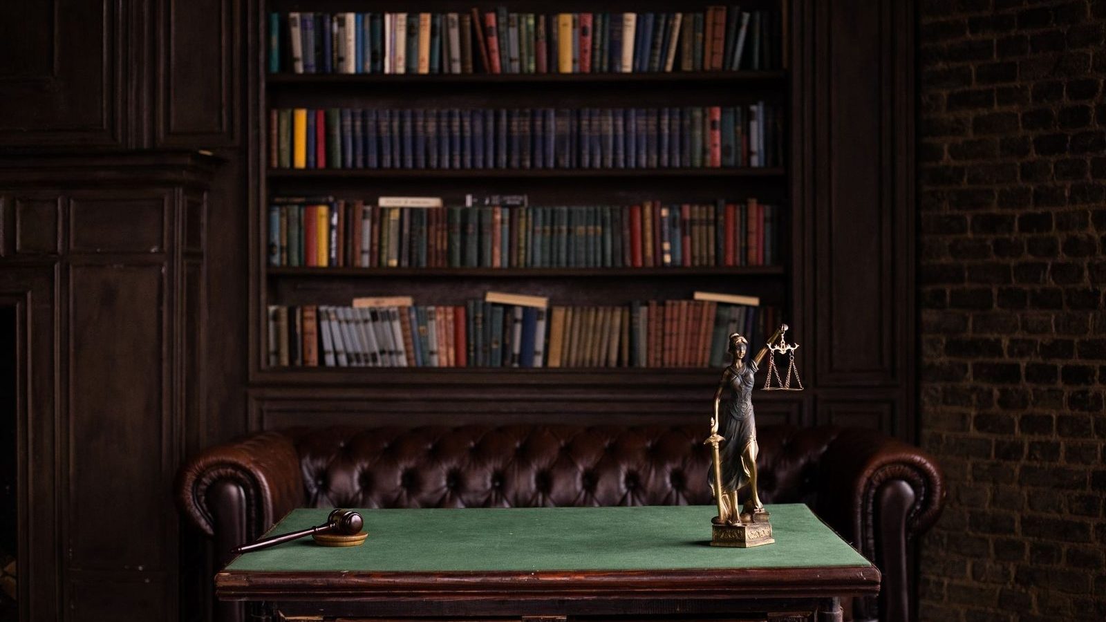 A study with shelves of law books, a gavel and a statue of Lady Justice