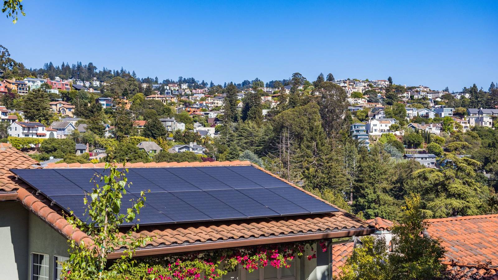 Solar panels on the tiled roof of a hillside home