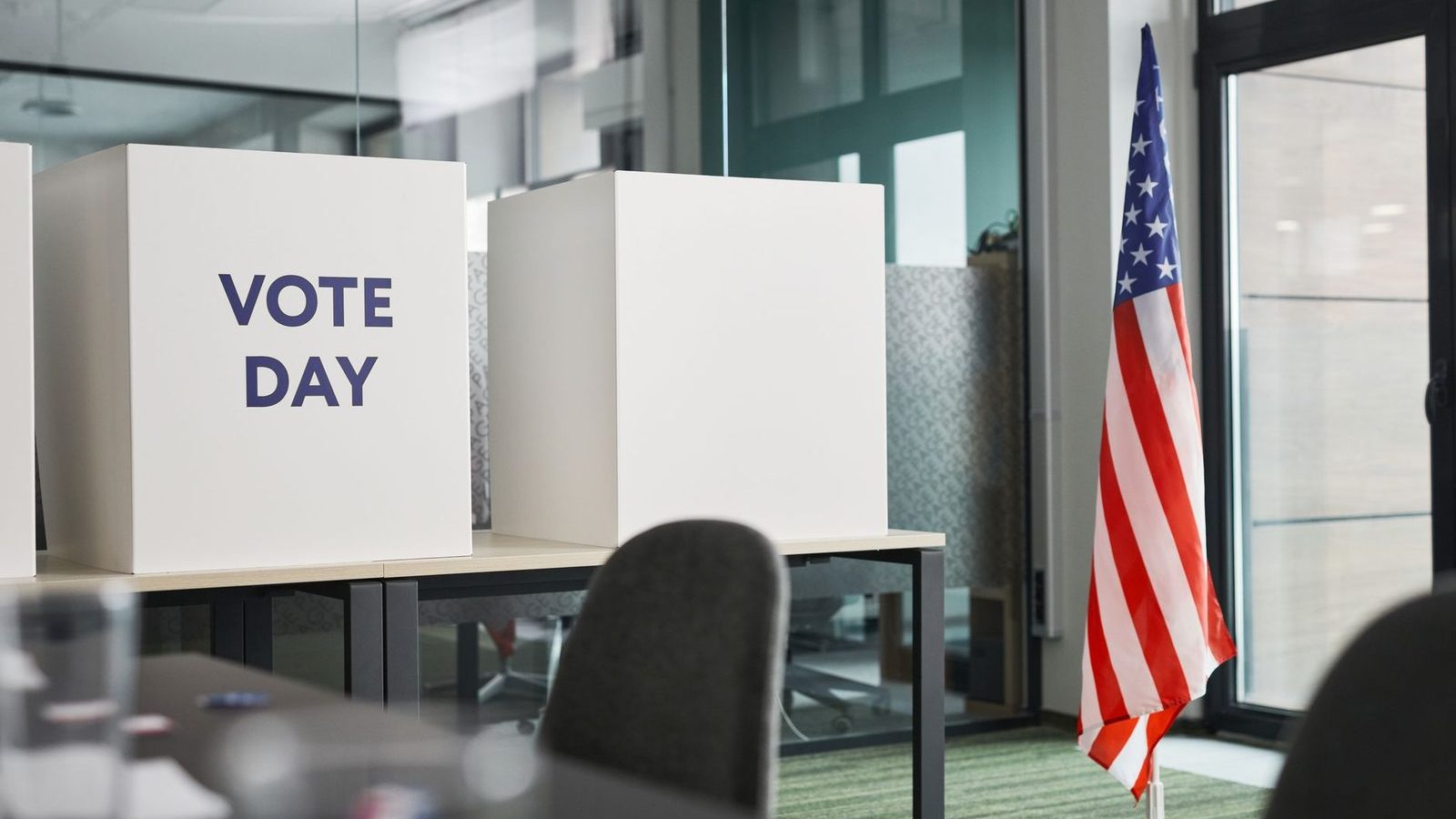 Voting booths marked Vote Day beside an American flag